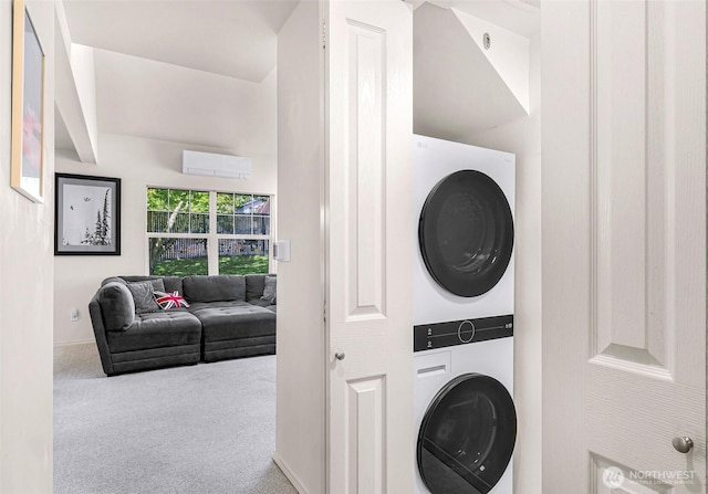 laundry area featuring stacked washer / dryer, carpet floors, and baseboards