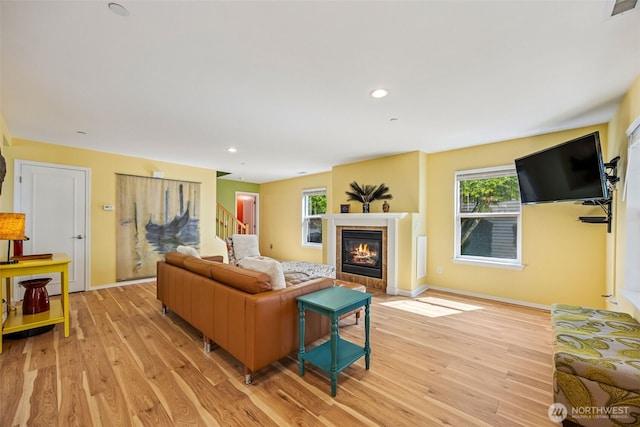 2758 Mcneil St, Dupont, WA 98327 - living area featuring light wood-type flooring, a tiled fireplace, stairway, baseboards, and recessed lighting