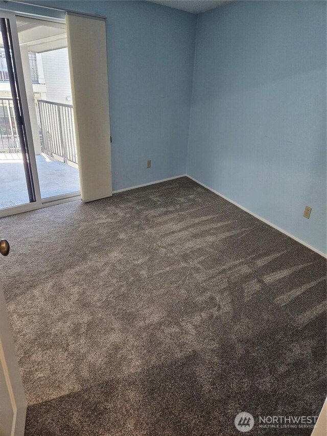 carpeted empty room featuring plenty of natural light and baseboards