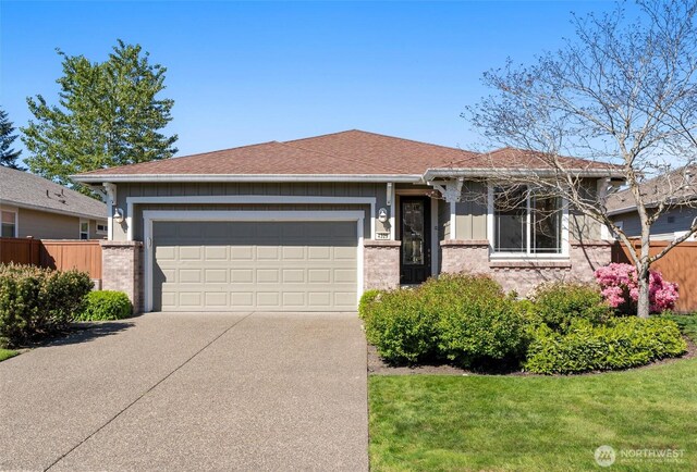single story home featuring concrete driveway, a garage, fence, and brick siding