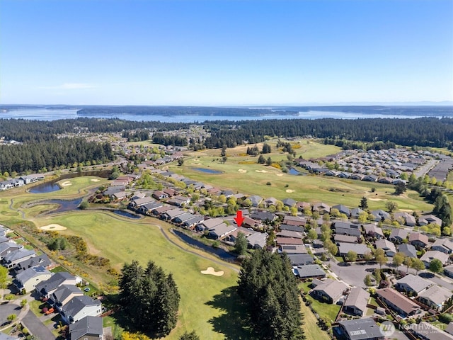 aerial view of property and surrounding area with nearby suburban area, a golf course, and a nearby body of water