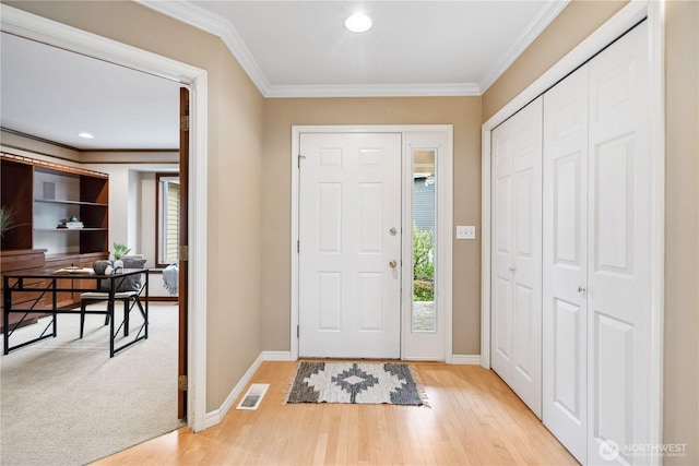entryway with ornamental molding, baseboards, light wood-style floors, and recessed lighting