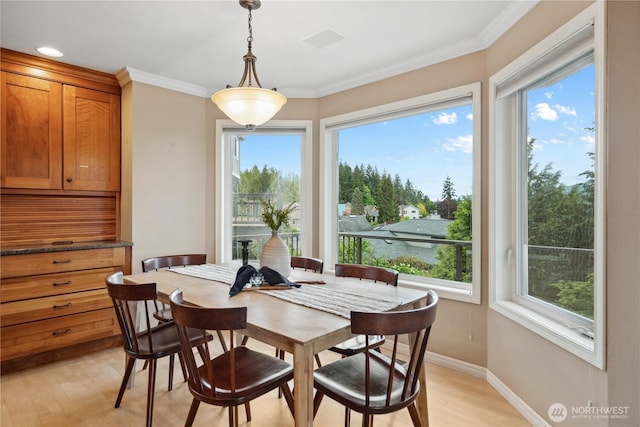 dining area with light wood-type flooring, baseboards, and ornamental molding