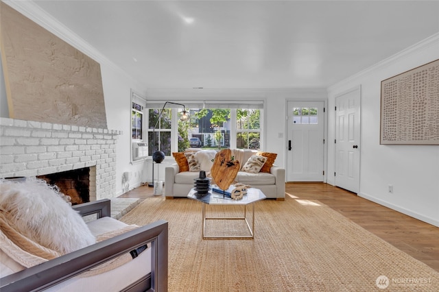 living room featuring wood finished floors, ornamental molding, a brick fireplace, and baseboards