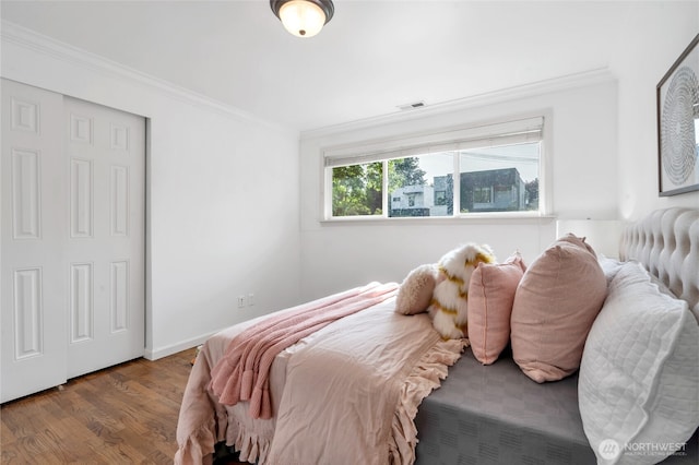 bedroom with crown molding and wood finished floors