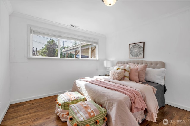 bedroom featuring ornamental molding, baseboards, and wood finished floors