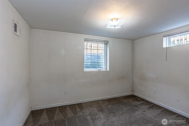 spare room with carpet floors, baseboards, and a textured ceiling