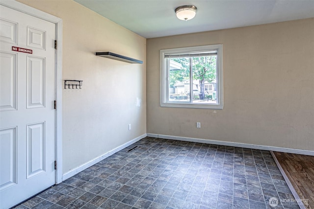 spare room featuring baseboards and stone finish flooring
