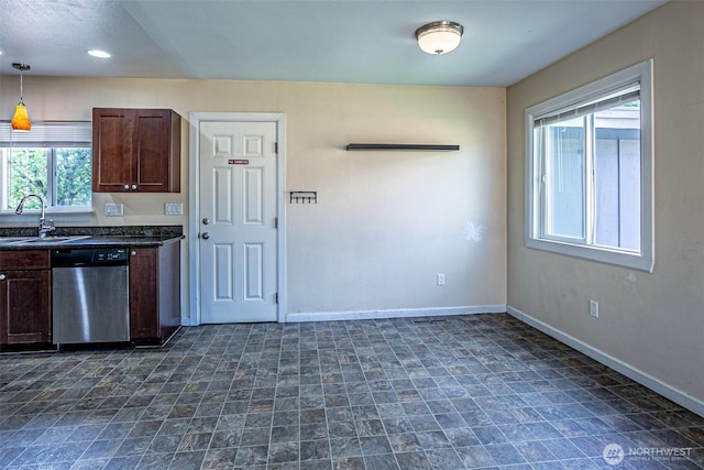 kitchen featuring stainless steel dishwasher, a sink, dark countertops, baseboards, and dark brown cabinetry