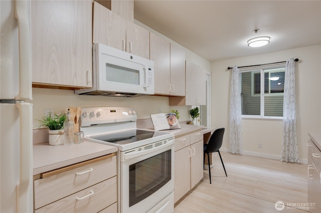 18210 73rd Ave NE Unit 101, Kenmore, WA 98028 - kitchen featuring white appliances, light countertops, light wood-style floors, and baseboards
