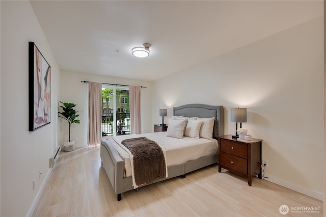 18210 73rd Ave NE Unit 101, Kenmore, WA 98028 - bedroom featuring baseboard heating, light wood-type flooring, and baseboards
