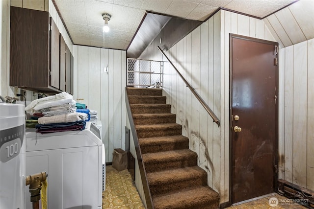 stairs with washer / clothes dryer and wooden walls