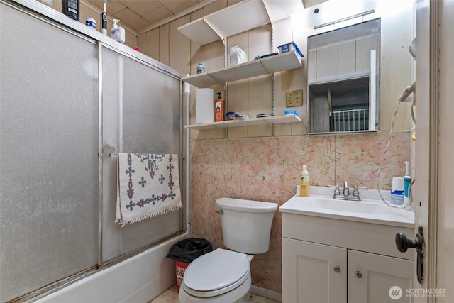 bathroom with vanity, toilet, and bath / shower combo with glass door