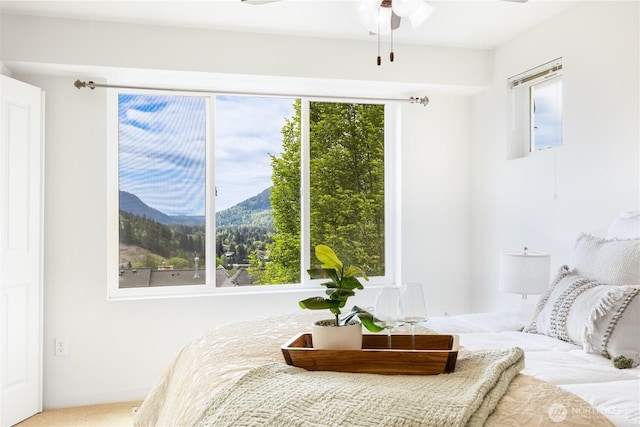 bedroom with a mountain view and a ceiling fan