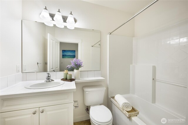 bathroom featuring toilet, shower / washtub combination, and vanity