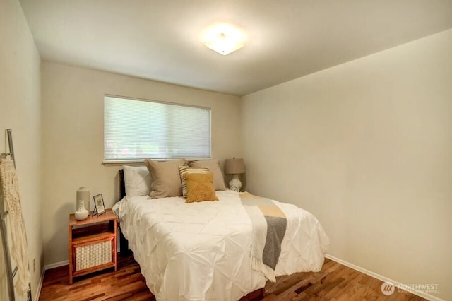 bedroom with wood finished floors and baseboards