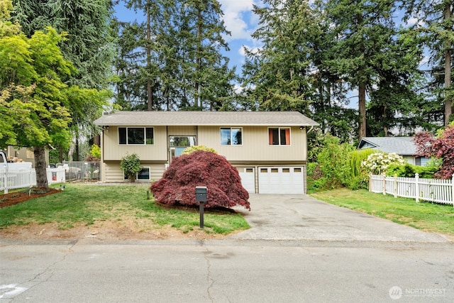 raised ranch with concrete driveway and an attached garage