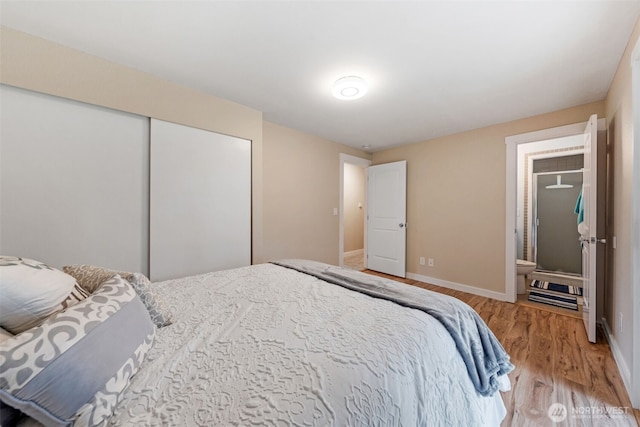 bedroom with light wood finished floors, a closet, and baseboards