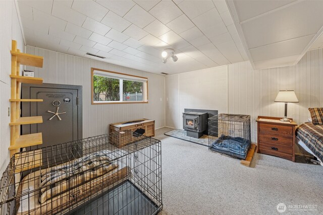 living area with a wood stove and carpet floors