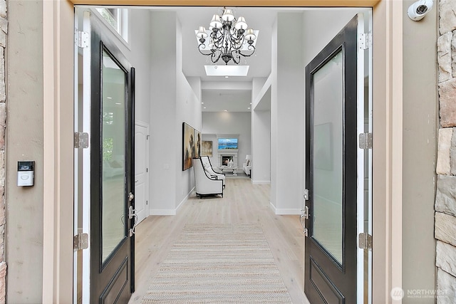1038 Belfair Rd, Bellevue, WA 98004 - foyer featuring light wood finished floors, a chandelier, and baseboards