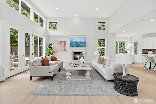 1038 Belfair Rd, Bellevue, WA 98004 - living room featuring a high ceiling, light wood-type flooring, a warm lit fireplace, and recessed lighting