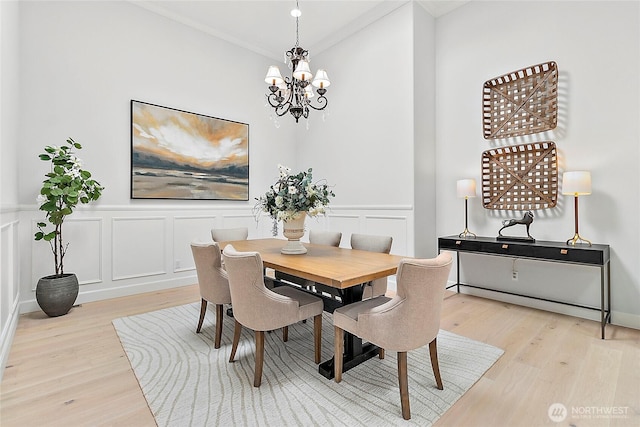 1038 Belfair Rd, Bellevue, WA 98004 - dining space with wood finished floors, ornamental molding, a chandelier, a decorative wall, and wainscoting