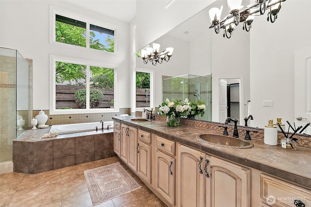 1038 Belfair Rd, Bellevue, WA 98004 - bathroom featuring a towering ceiling, a chandelier, tile patterned flooring, a stall shower, and double vanity