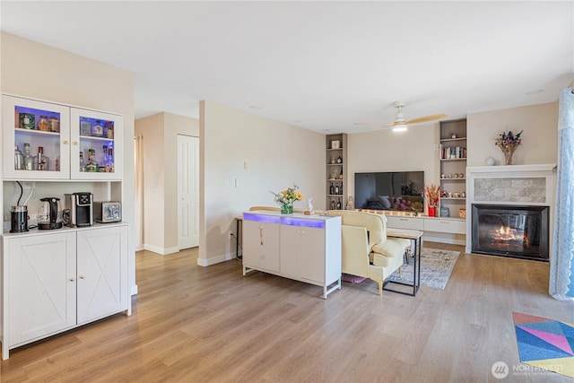 15623 NE 18th St Unit D201, Bellevue, WA 98008 - living room featuring light wood finished floors, a fireplace, a ceiling fan, and built in features