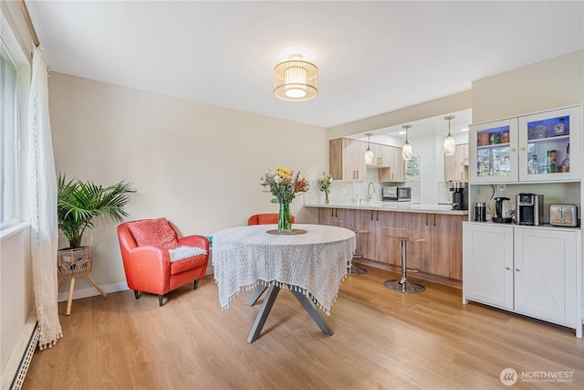 15623 NE 18th St Unit D201, Bellevue, WA 98008 - dining room with light wood finished floors, baseboard heating, and baseboards