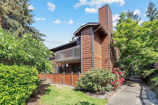 15623 NE 18th St Unit D201, Bellevue, WA 98008 - view of side of home with a chimney, a balcony, and fence