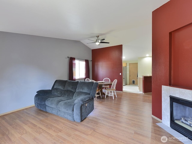 16312 72nd Ave E, Puyallup, WA 98375 - living room with ceiling fan, light wood-type flooring, vaulted ceiling, a tile fireplace, and baseboards