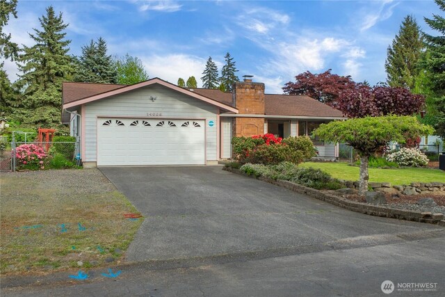 ranch-style house featuring driveway, a chimney, and an attached garage