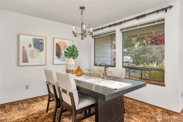 carpeted dining space featuring a chandelier, a textured ceiling, and baseboards
