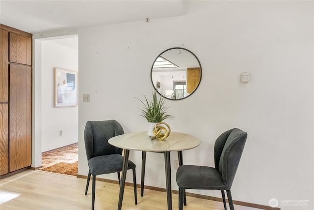dining room featuring light wood-style floors and baseboards