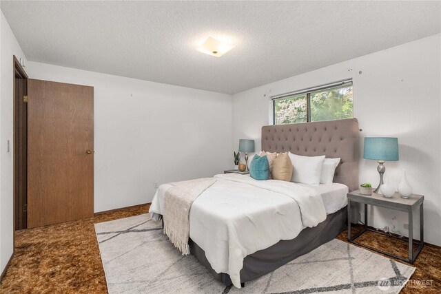 carpeted bedroom featuring a textured ceiling