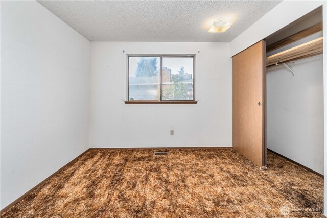 unfurnished bedroom with a closet, carpet, and a textured ceiling