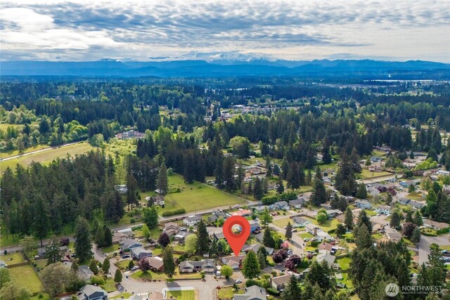 drone / aerial view of a mountainous background and a heavily wooded area