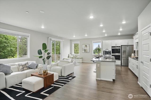 living room featuring plenty of natural light, recessed lighting, and dark wood finished floors