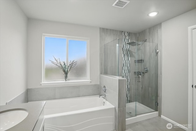 bathroom with a stall shower, a bath, recessed lighting, tile patterned floors, and vanity