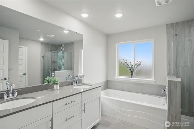 bathroom with a shower stall, recessed lighting, a garden tub, double vanity, and tile patterned flooring
