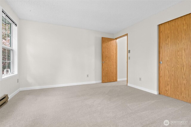 unfurnished room featuring carpet flooring, baseboards, and a textured ceiling