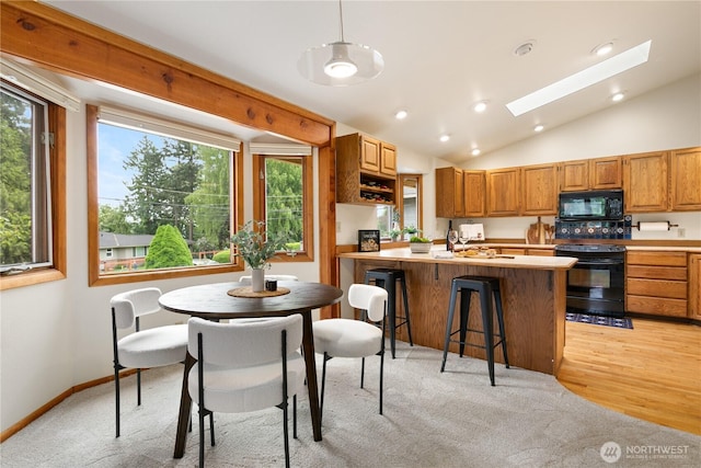 12013 Exeter Ave NE, Seattle, WA 98125 - kitchen featuring black appliances, a skylight, lofted ceiling, light countertops, and healthy amount of natural light