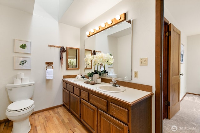 12013 Exeter Ave NE, Seattle, WA 98125 - full bath featuring double vanity, wood finished floors, baseboards, and toilet