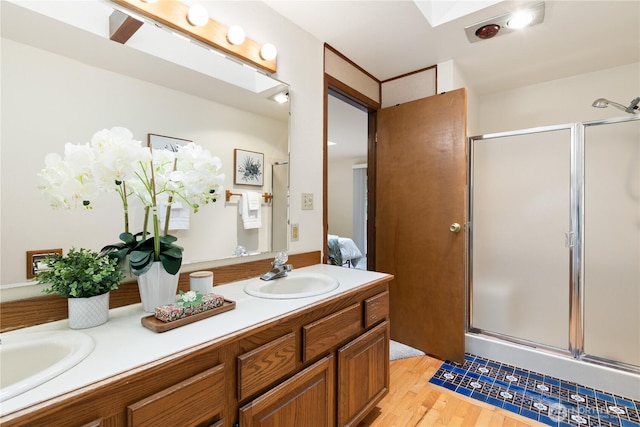 12013 Exeter Ave NE, Seattle, WA 98125 - full bathroom with double vanity, a shower stall, and wood finished floors