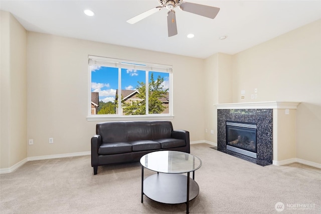 carpeted living room featuring ceiling fan, recessed lighting, a high end fireplace, and baseboards