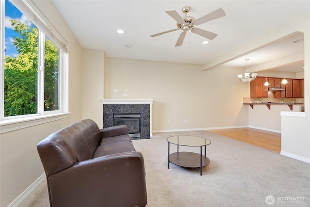 living area with light colored carpet, a high end fireplace, baseboards, recessed lighting, and a chandelier
