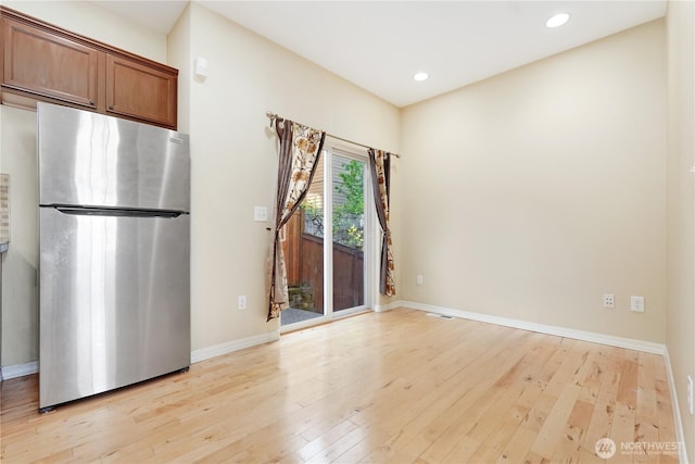 empty room with light wood-style flooring, recessed lighting, and baseboards
