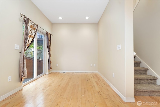 empty room with light wood-style floors, stairs, baseboards, and recessed lighting