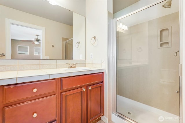 bathroom featuring a stall shower, vanity, and a ceiling fan