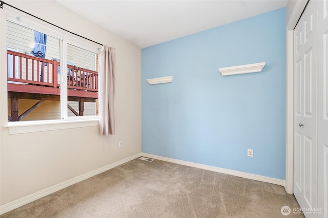 carpeted empty room featuring baseboards